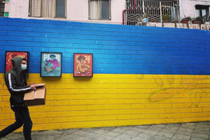 Ein Mann läuft an einer blau-gelb gestrichenen Mauer entlang.