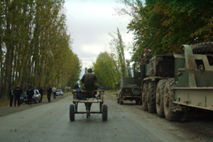 Straße mit einem Panzer, einem Eselskarren und Polizei