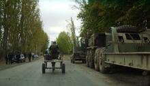 Straße mit einem Panzer, einem Eselskarren und Polizei